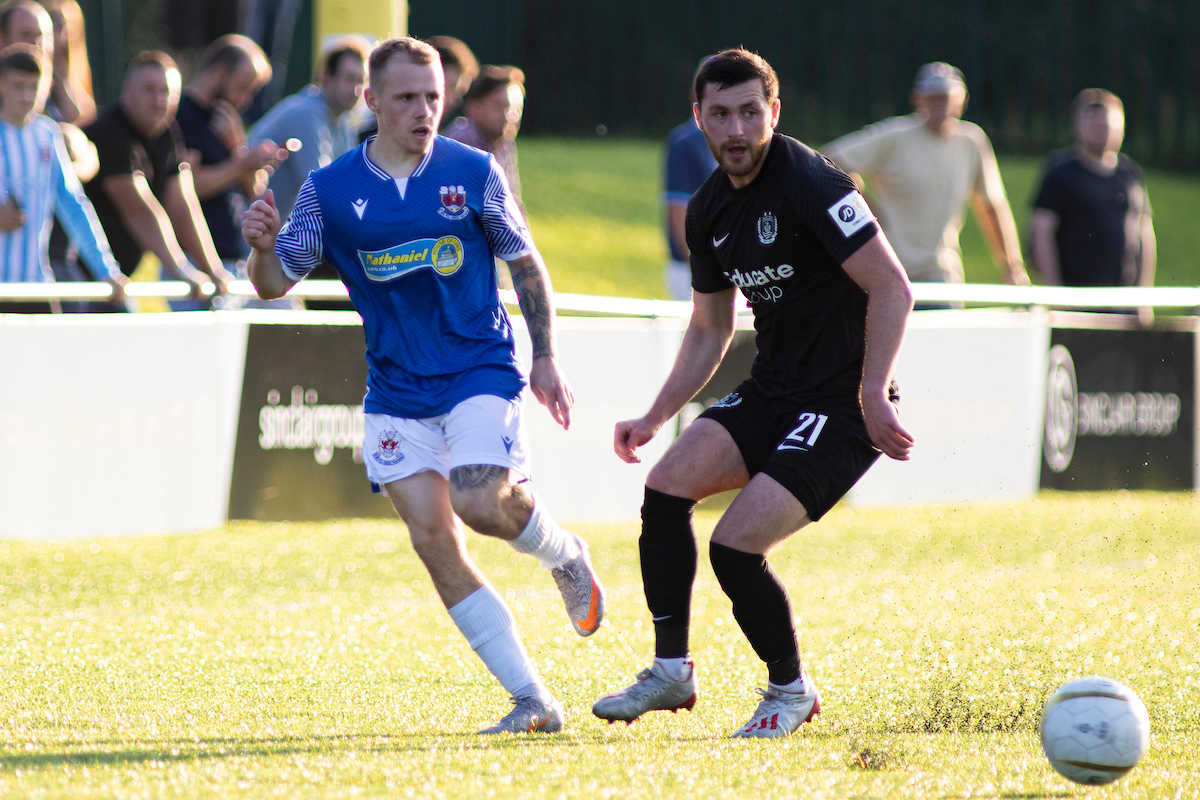 Footballers running for ball